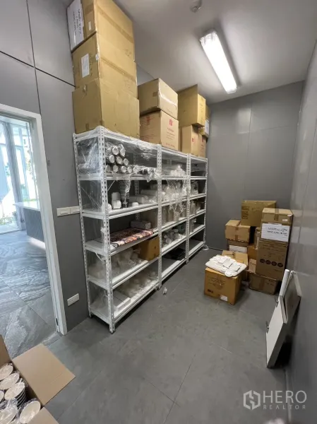 Retail Space for rent in Khlong Toei, Bangkok - Back-of-house storage room with metal shelving and tiled floors for inventory.