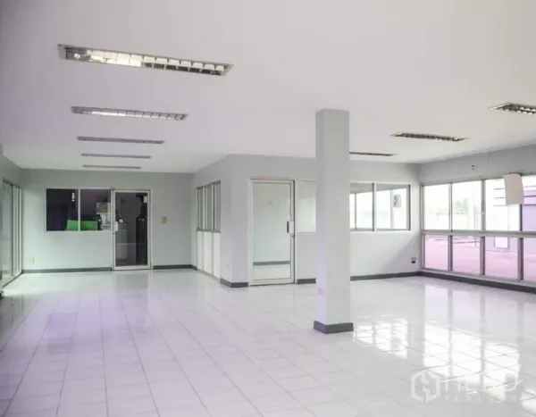 工厂 出租在Pathum Thani - 明亮的办公室内景，瓷砖地面、玻璃隔间与荧光灯。