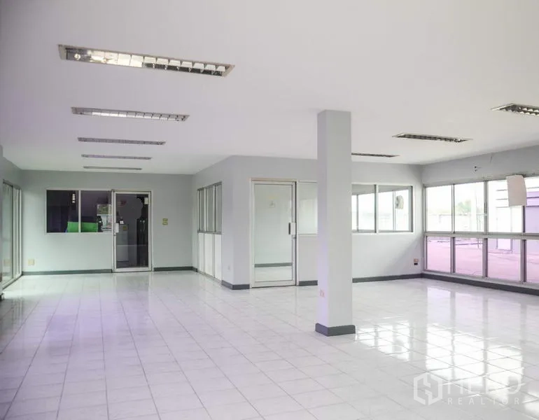 工厂 出租在Pathum Thani - 明亮的办公室内景，瓷砖地面、玻璃隔间与荧光灯。