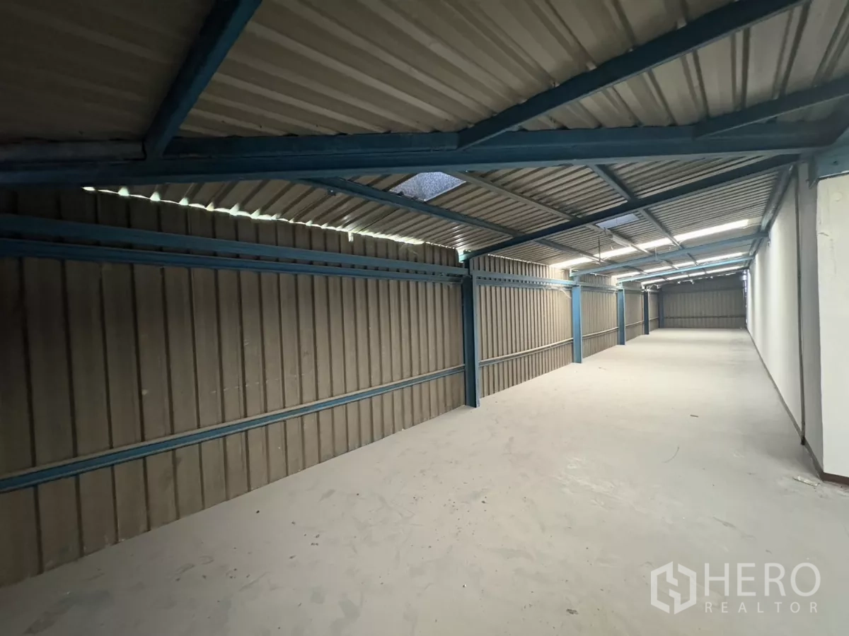 Factory for rent in Khlong Toei, Bangkok - Long mezzanine storage zone with metal cladding and strip lighting.