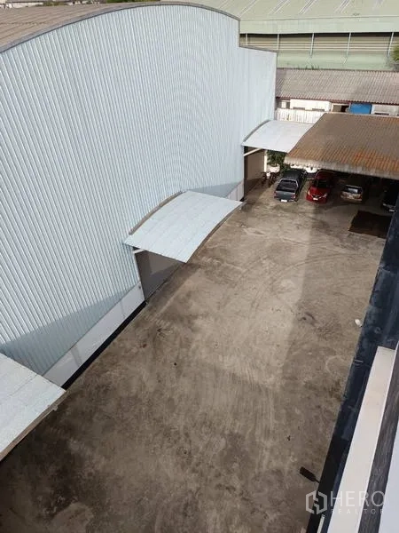 โรงงาน ขายในBan Phaeo, Samut Sakhon - ภาพมุมสูงของลานด้านข้างติดโกดังผนังเมทัลชีท มีหลังคาโหลดสินค้าและที่จอดรถ