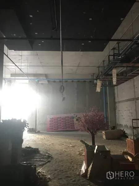Retail Space for rent in Khlong Toei, Bangkok - Large shell retail area with hanging conduits and natural light entering from the side.
