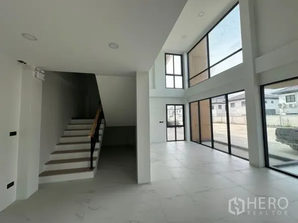 Warehouse for sale in Lam Luk Ka, Pathum Thani - Double-height office lobby with floor-to-ceiling windows and staircase.