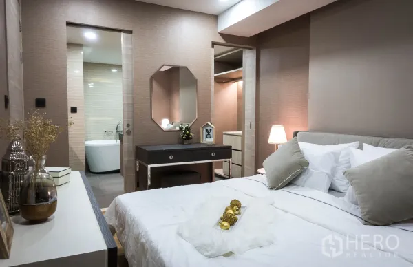คอนโด ให้เช่าในPathum Wan, Bangkok - มุมห้องนอนพร้อมโต๊ะเครื่องแป้ง ทางเข้าโซนวอล์กอินคลอเซ็ต และประตูสู่ห้องน้ำในตัว.
