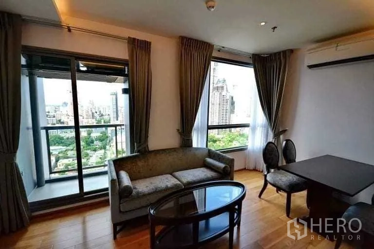 Condominium for rent or sale in Phra Khanong, Bangkok - Bright living room with balcony and skyline view in a Phra Khanong condo.
