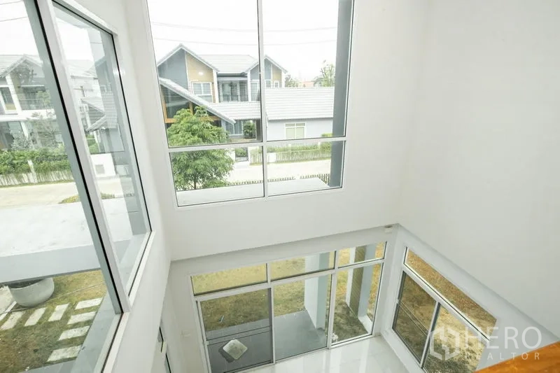 Detached House for rent or sale in Lam Luk Ka, Pathum Thani - Another angle of the double-height space and sliding glass doors to the garden.
