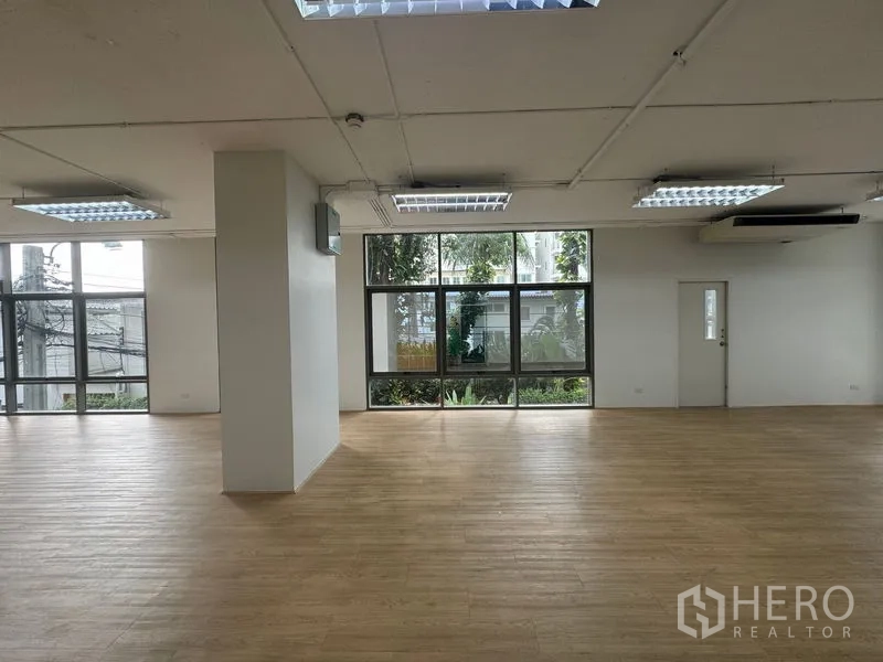 办公空间 出租在Sathon, Bangkok - 宽敞工作空间，木纹地板，多组天花灯，窗外绿意。