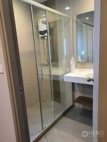 คอนโด ให้เช่า - ห้องน้ำพร้อมฉากกั้นอาบน้ำกระจก เครื่องทำน้ำอุ่น และอ่างล้างหน้าพร้อมกระจกบานใหญ่