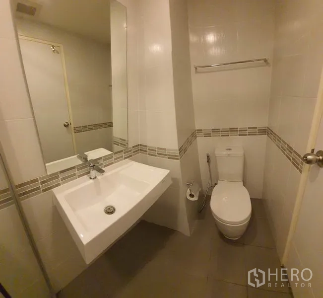 公寓 出售在Chatuchak, Bangkok - 整洁卫浴，方形台盆、马桶与中性色瓷砖。
