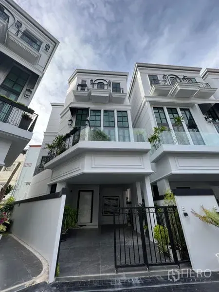带办公室的家 出租或出售在Watthana, Bangkok - 三层白色住办公房外观，带大窗与可上锁车棚。