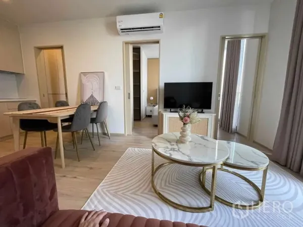 公寓 出租在Watthana, Bangkok - 温馨客厅，圆形叠式大理石茶几、电视柜，可通往阳台。