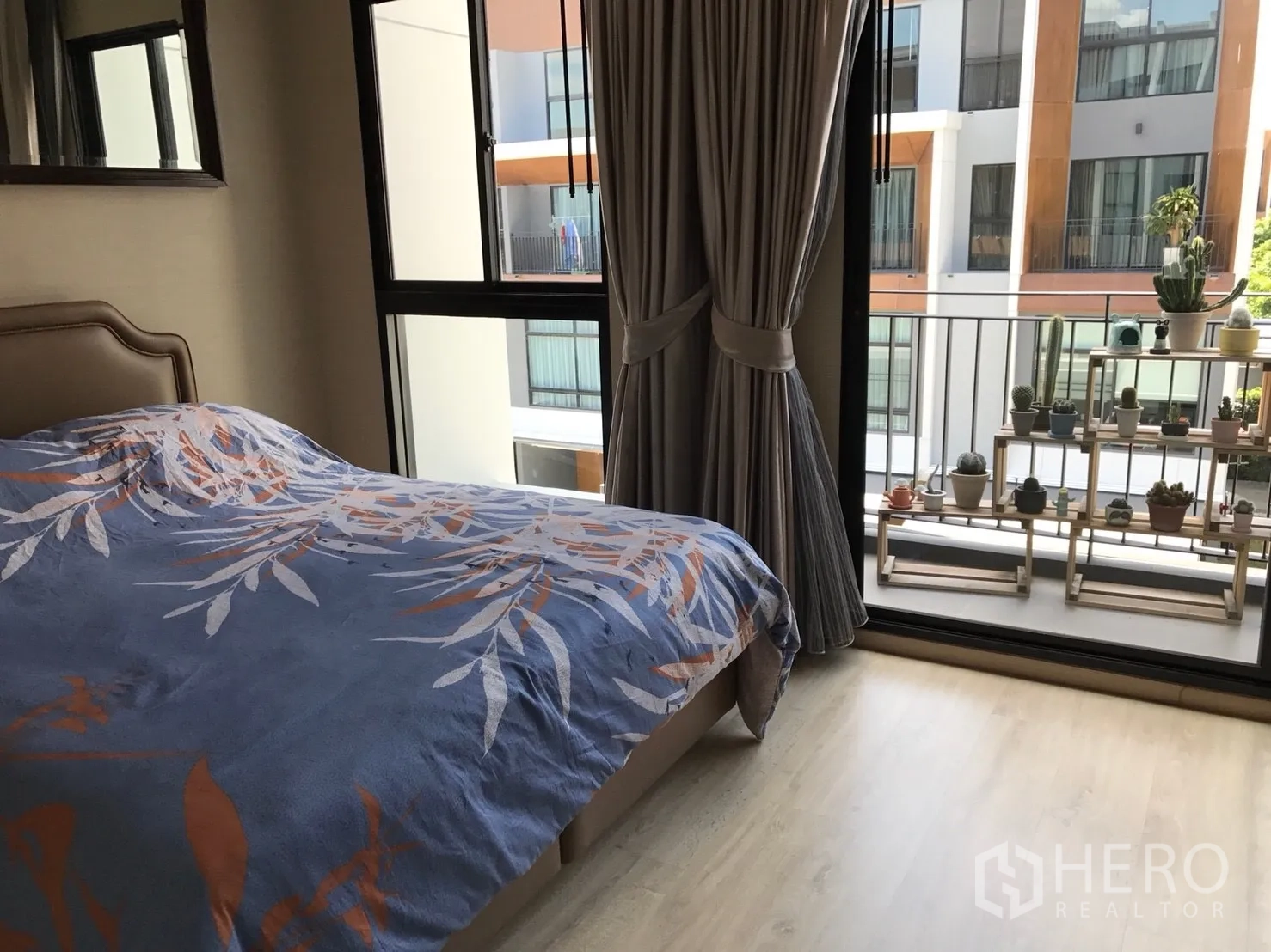 Townhouse for sale in Suan Luang, Bangkok - Bedroom with private balcony and potted plant shelving, floor-to-ceiling curtains