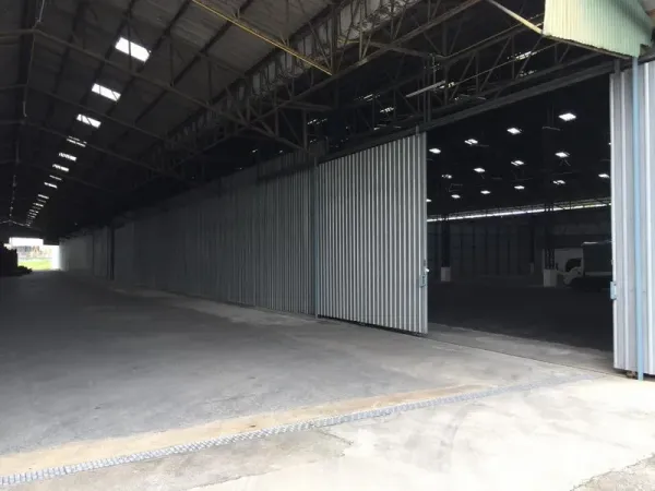 Warehouse for rent in Mueang Pathum Thani, Pathum Thani - Large sliding metal doors with covered loading area allowing truck access to the warehouse.