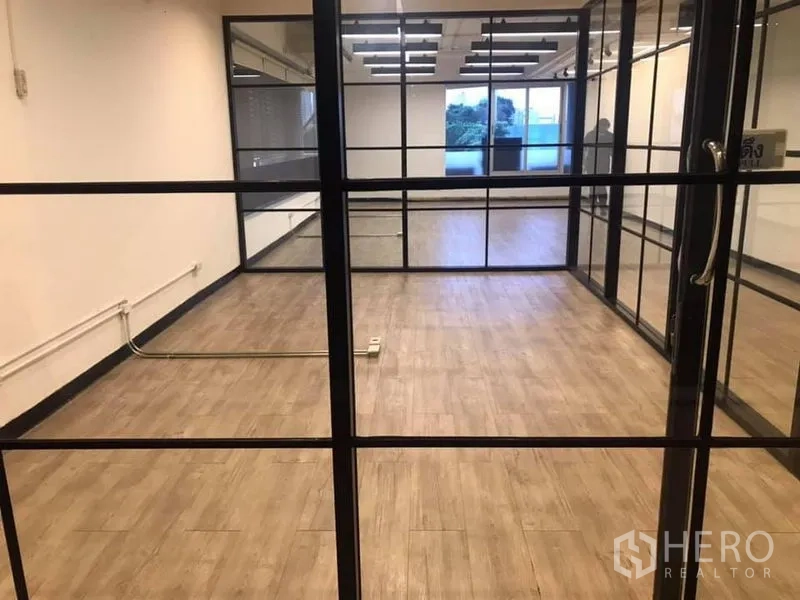 Office Space for rent in Khlong Toei, Bangkok - Glass-door meeting room inside a modern office featuring timber-look flooring and black framed partitions.