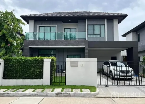 Detached House for sale in Khan Na Yao, Bangkok - Modern two-storey detached house with glass balcony, gated front yard and covered carport.