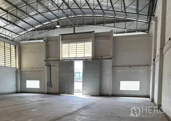 โรงงาน ให้เช่าในKrathum Baen, Samut Sakhon - พื้นที่ภายในโรงงาน เพดานสูง โครงหลังคาเหล็ก ประตูบานสไลด์ขนาดใหญ่ และช่องลมระบายอากาศ