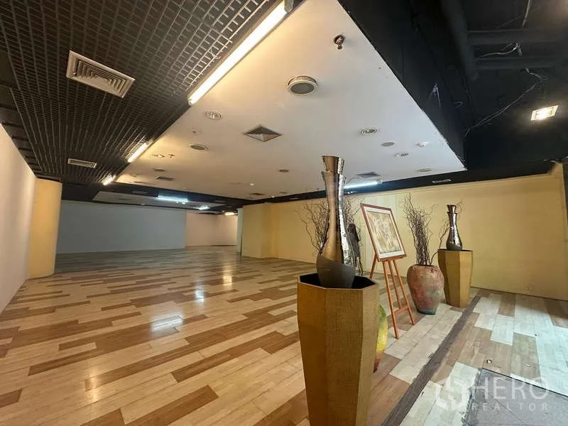 Retail Space for rent - Showroom zone with decorative vases and framed art beside a feature yellow wall.