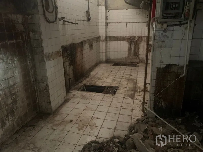 Shophouse for rent in Watthana, Bangkok - Stripped kitchen area with white tiles, floor drains and exposed services.