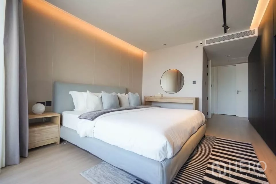 公寓 出租在Bang Phlat, Bangkok - 宽敞主卧，软包大床、暖色灯带与嵌入式衣柜。