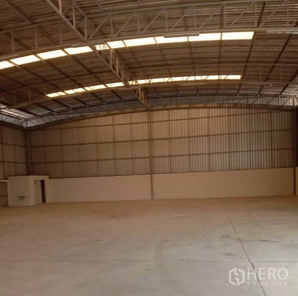 Warehouse for rent in Lat Krabang, Bangkok - Clear-span warehouse space with corrugated metal walls, utility room and wide open floor for racking or staging.