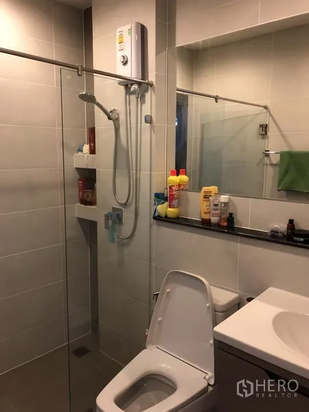 Detached House for rent in Saphan Sung, Bangkok - Modern bathroom with glass-enclosed shower, vanity and toilet.