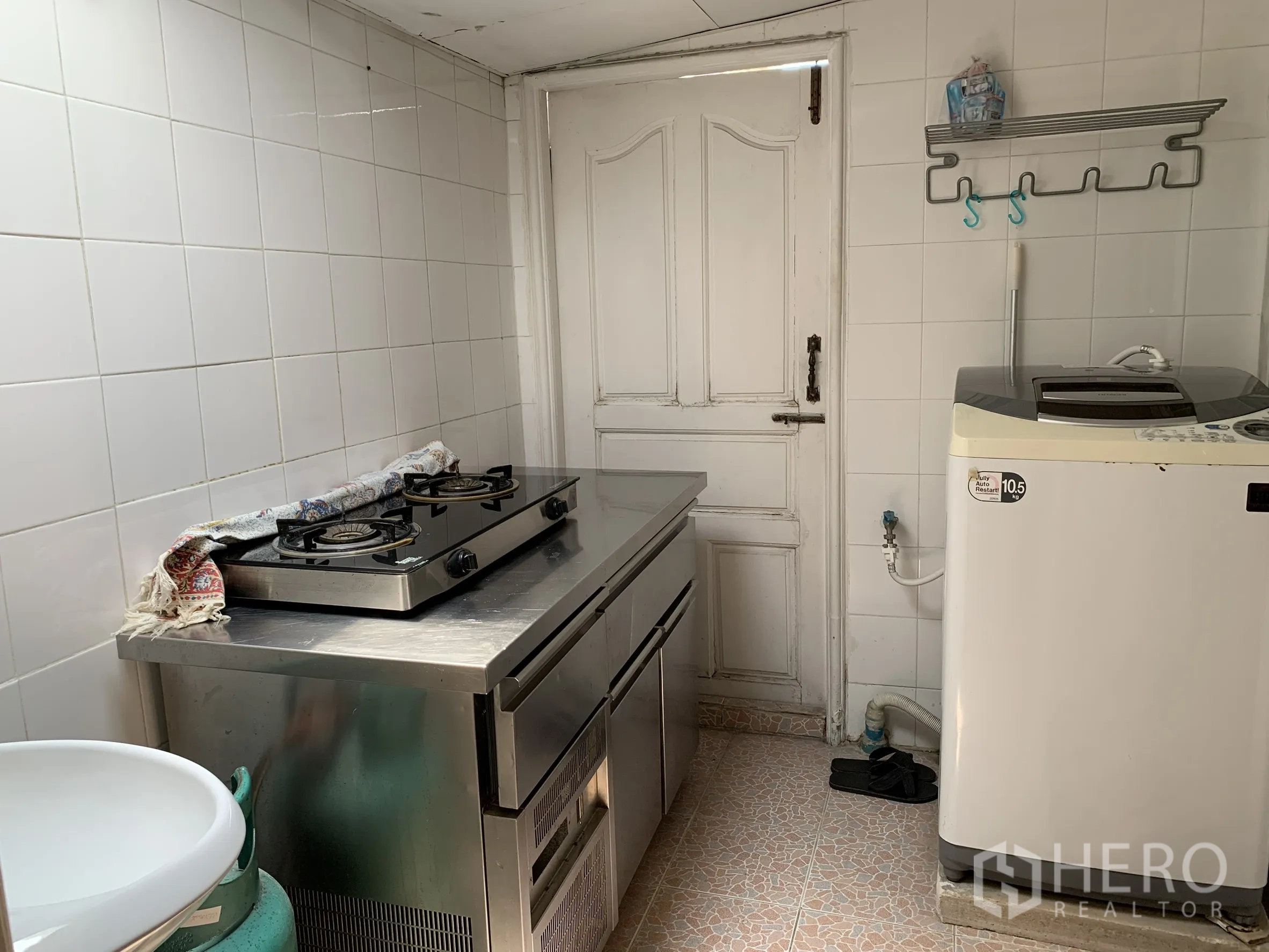 独栋房屋 for rent in Saphan Sung, Bangkok - 紧凑厨房，配不锈钢台面燃气灶、瓷砖墙面与洗衣机。