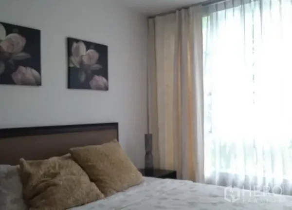公寓 出租在Khlong Toei, Bangkok - 第二卧室设棕色床头、花卉挂画和高窗薄帘。
