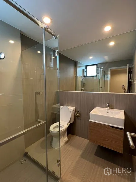 Townhouse for rent in Suan Luang, Bangkok - Contemporary bathroom with a glass-enclosed shower, vanity and toilet.