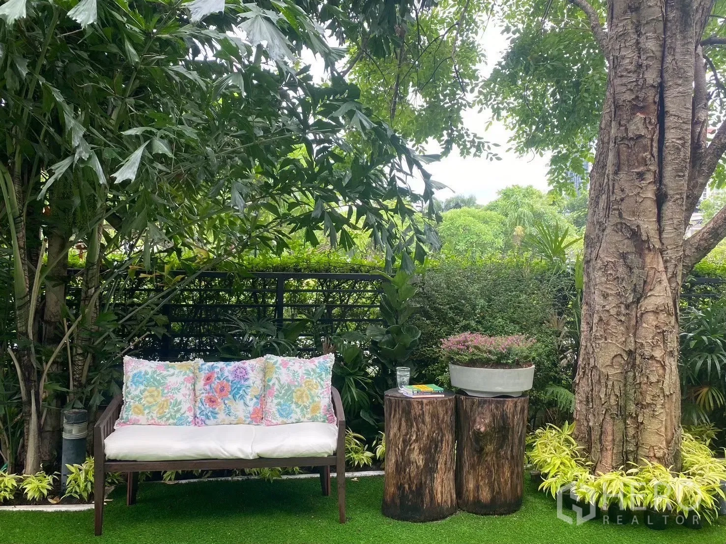 独栋房屋 for sale in Suan Luang, Bangkok - 花园长椅与木桩边几，置于大树与绿篱下。