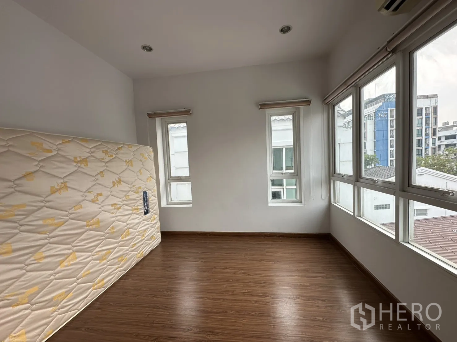 โฮมออฟฟิศ for rent in Watthana, Bangkok - ห้องมุมมีหน้าต่างรอบด้าน พื้นไม้ วางที่นอนพิงผนัง