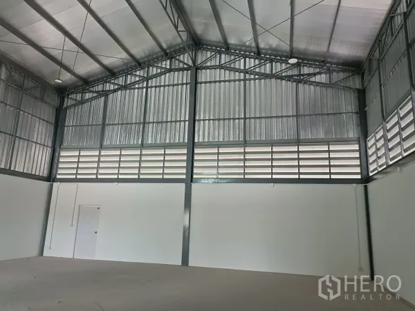 Warehouse for rent or sale in Bang Yai, Nonthaburi - Spacious warehouse interior with high gable steel roof, insulation and louvered ventilation panels.