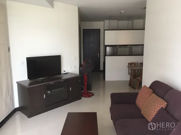 Condominium for rent in Khlong Toei, Bangkok - Bright living room with TV console, sofa and tiled flooring in a modern Bangkok condo.