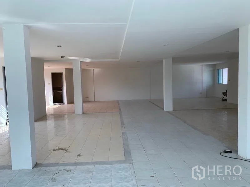 Office Space for rent in Huai Khwang, Bangkok - Expansive open-plan office floor with tiled surfaces, white columns and recessed ceiling lights.