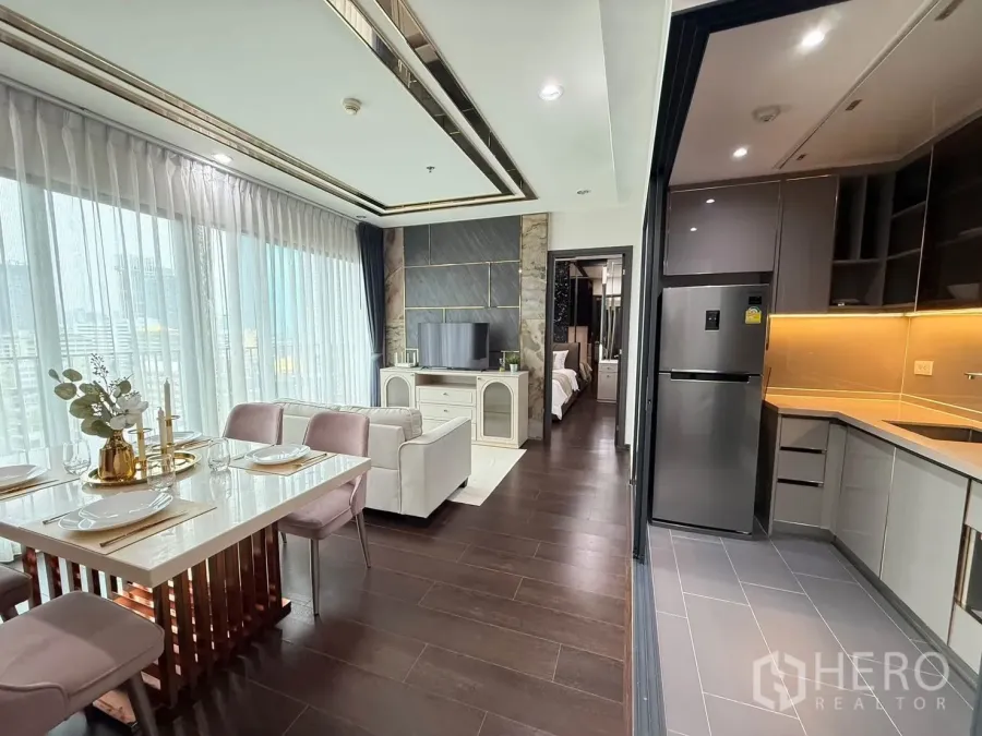 Condominium for rent in Watthana, Bangkok - Kitchen with ample cabinetry and fridge overlooking the dining and living area.
