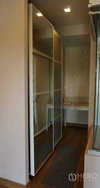 Condominium for sale in Khlong Toei, Bangkok - Hallway with mirrored sliding wardrobe and a compact dressing table.