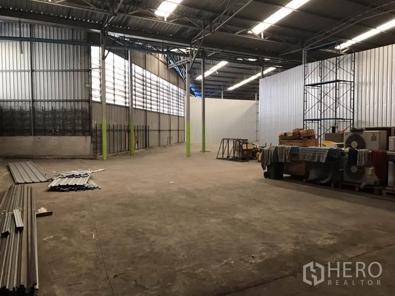 Warehouse for rent in Bang Na, Bangkok - Wide warehouse interior with steel columns, skylight strips and ventilation panels, open storage area.