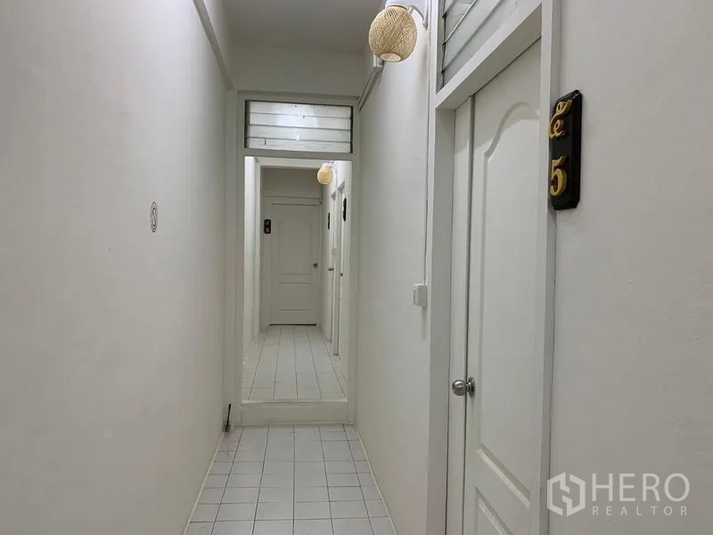 Shophouse for rent in Khlong Toei, Bangkok - Bright hallway with a mirror at the end and numbered white doors.