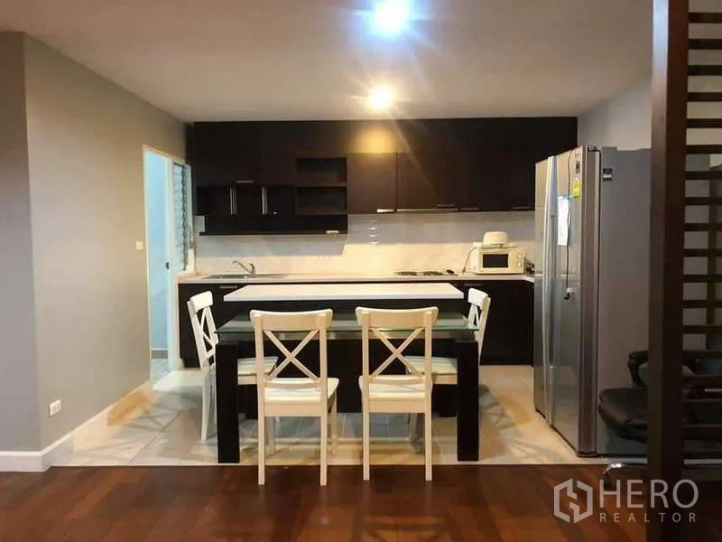 Condominium for sale in Yan Nawa, Bangkok - Full kitchen view with breakfast island and four white dining chairs.