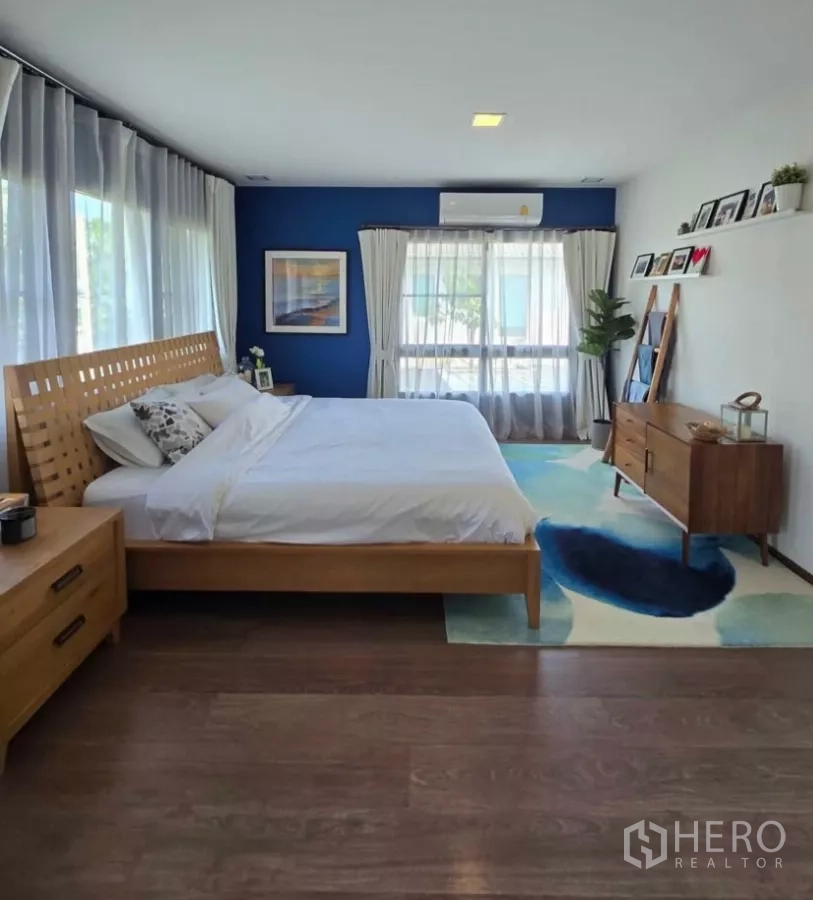 Detached House for rent in Bang Phli, Samut Prakan - Spacious master bedroom with wood flooring, area rug and full-height curtains