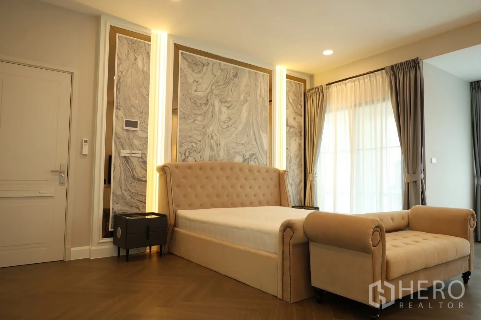 Detached House for rent or sale in Saphan Sung, Bangkok - Master bed with tufted headboard, marble accent panels, and floor-to-ceiling drapes.