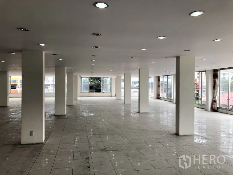 Retail Space for rent in Lam Luk Ka, Pathum Thani - Large open retail floor with rows of downlights, wraparound windows and sliding glass doors.