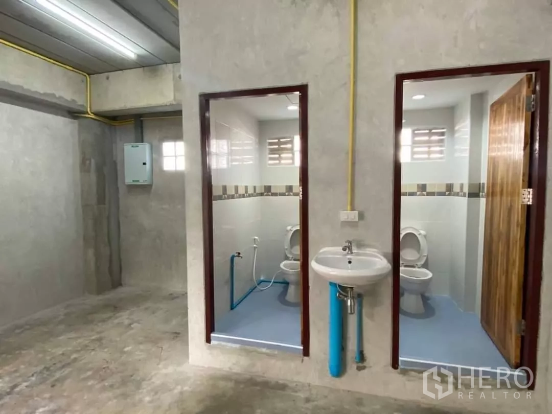 货栈 出租在Min Buri, Bangkok - 仓库内卫生间，两个坐便间与壁挂式洗手盆，整洁明亮。