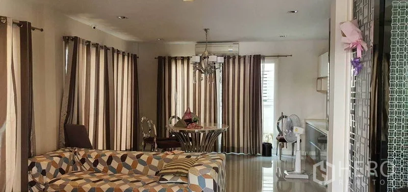Detached House for sale in Khan Na Yao, Bangkok - Spacious lounge and dining area with full-height curtains, chandelier and air-conditioning.