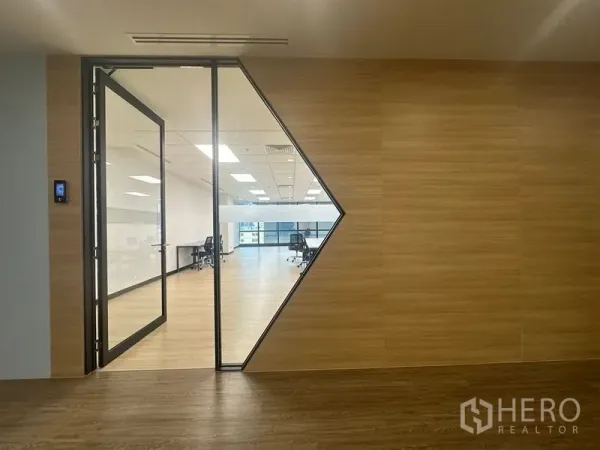 办公空间 出租在Chatuchak, Bangkok - 带三角形玻璃面板的现代办公入口，通向开放工作区