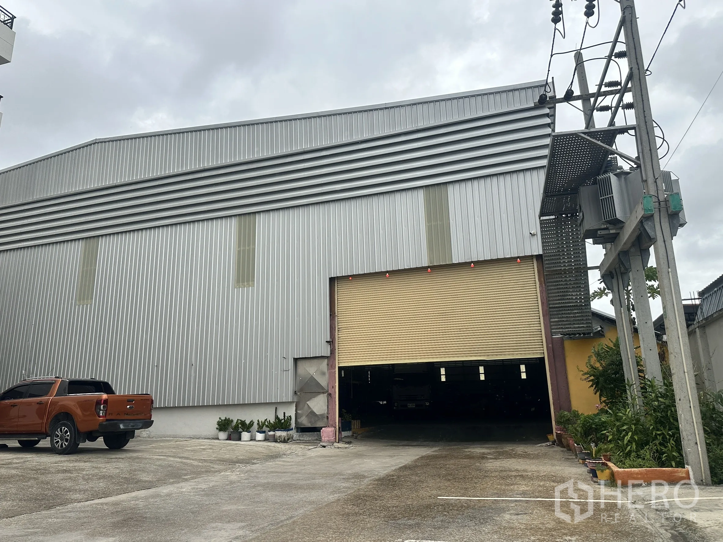 仓库 for rent in Mueang Samut Prakan, Samut Prakan - 仓库正面，入口旁设有装卸区与停车位。