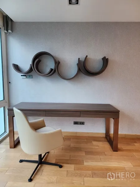 Condominium for rent in Khlong Toei, Bangkok - Study nook with writing desk and sculptural wall shelves.