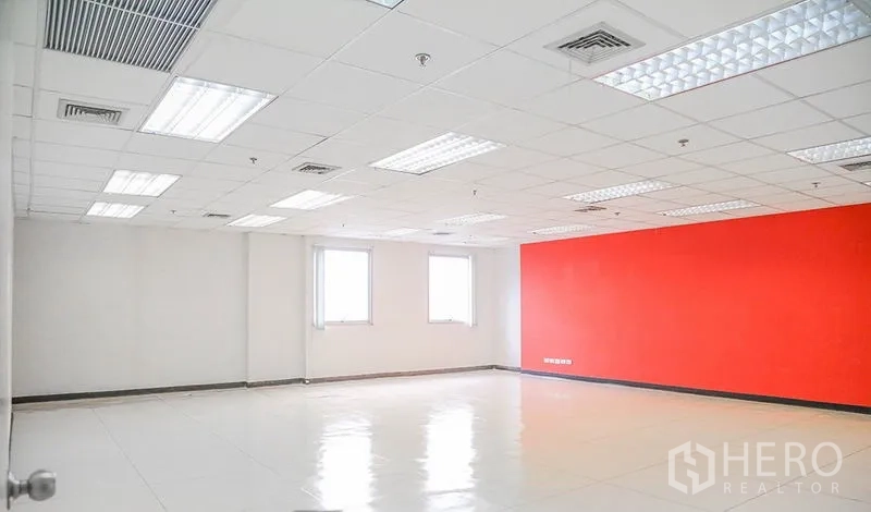 办公空间 出租在Bang Na, Bangkok - 开放办公室，两扇窗、红色特色墙和网格吊顶灯。
