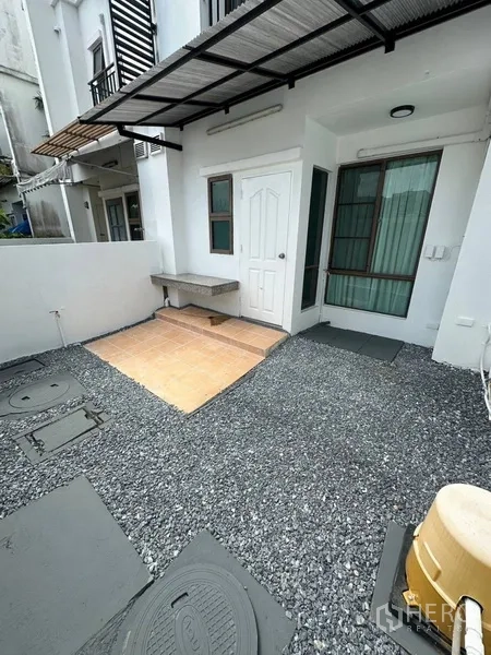 Townhouse for rent or sale in Phra Khanong, Bangkok - Rear patio with sink, gravel yard, and service door.