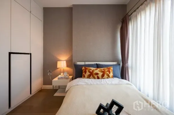 Condominium for rent or sale in Khlong Toei, Bangkok - Second bedroom with a single bed, built-in wardrobe and large windows.
