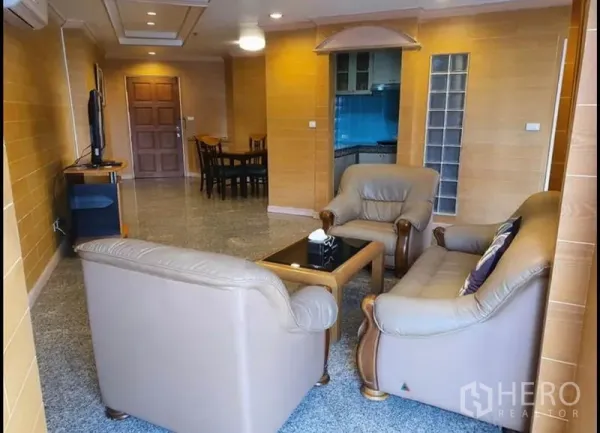 公寓 出租在Ratchathewi, Bangkok - 宽敞客厅，真皮沙发组、电视与石材地面，曼谷公寓。